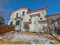 Two-story home with white siding, red accents, and a wooden fence at 395 Longspur Dr, Brighton, CO 80601