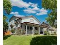 Well-maintained home featuring a spacious wrap-around porch and manicured lawn at 395 Longspur Dr, Brighton, CO 80601