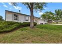 Landscaped front yard showcasing a mature tree, well-maintained lawn, and the home's exterior at 4425 S Zang St, Morrison, CO 80465