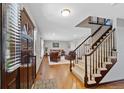 Spacious entryway featuring hardwood floors, stairs with carpet and dark wood trim and a view into the living room at 5775 S Pagosa Way, Centennial, CO 80015