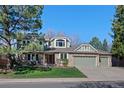 Charming two-story home featuring a brick and siding exterior, a well-manicured lawn, and an attached three-car garage at 5775 S Pagosa Way, Centennial, CO 80015