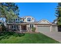 Charming two-story home with brick and siding, lush lawn, and a three car attached garage at 5775 S Pagosa Way, Centennial, CO 80015
