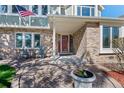 Inviting front porch with brick detail, featuring a 'Welcome' sign on the front door and outdoor seating at 5775 S Pagosa Way, Centennial, CO 80015