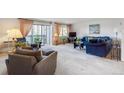 Inviting living room featuring plush seating, neutral carpeting, and sliding glass doors to a balcony at 13631 E Marina Dr # 201, Aurora, CO 80014