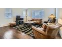 Comfortable living room with hardwood floors, plenty of natural light, and stylish furniture at 10057 Granby St, Commerce City, CO 80022