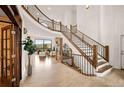 Grand foyer with a curved staircase, stone fireplace, and large windows offering scenic views at 24140 Us Highway 40, Golden, CO 80401