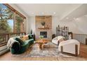 Cozy living room features a stone fireplace, modern furniture, and scenic views through large windows at 24140 Us Highway 40, Golden, CO 80401