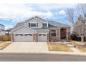 Two-story house with brick and siding, three-car garage, and landscaped yard at 18981 E Belleview Pl, Centennial, CO 80015