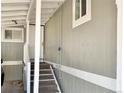 Exterior entryway leading up to the front door featuring white railings and light gray siding at 8480 Adams Way, Denver, CO 80229