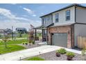 Home boasts a charming front porch, a two-car garage, and a beautifully landscaped front yard at 13315 Xanthia St, Thornton, CO 80602