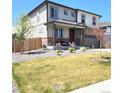 Two-story home with covered porch, lawn, manicured landscaping, and fenced yard at 13315 Xanthia St, Thornton, CO 80602