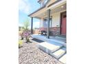 Inviting front porch featuring neutral siding, brick accents, seating, and manicured landscaping at 13315 Xanthia St, Thornton, CO 80602