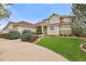 Charming exterior view of a well-maintained home with a lush green lawn, mature trees, and a paved driveway at 16 Blue Heron Dr, Thornton, CO 80241