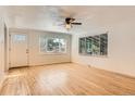 Bright living room with hardwood floors, ceiling fan, and large windows offering natural light at 695 S Quitman St, Denver, CO 80219