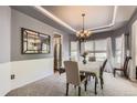 Formal dining room with elegant chandelier, neutral paint, and large mirror at 10330 Lions Path, Lone Tree, CO 80124