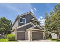 Two-story home showcasing gray siding, brick accents, a two-car garage, and a well-maintained lawn at 10330 Lions Path, Lone Tree, CO 80124