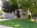 Beautiful home featuring a brick facade, well-maintained lawn, and mature trees enhancing curb appeal at 10330 Lions Path, Lone Tree, CO 80124
