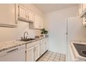 Kitchen area with white cabinets, granite countertops, and black and white tile flooring at 7665 E Eastman Ave # 111A, Denver, CO 80231