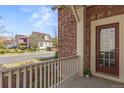 Inviting front porch view with brick accents and a glimpse of the peaceful neighborhood at 3529 Xanthia Ct, Denver, CO 80238