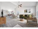 Bright living room featuring an open layout, vaulted ceiling, and neutral decor creating a cozy atmosphere at 56582 E 23Rd Ave, Strasburg, CO 80136