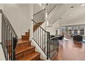 Elegant staircase with dark wood steps, white risers and black iron railings leading to the main floor at 3394 W 33Rd Ave, Denver, CO 80211