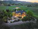 Aerial view showcases tiered patio, outdoor fireplace and entertainment area overlooking mountain scenery at 9650 S Cougar Rd, Littleton, CO 80127