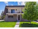 Two-story home featuring two balconies, a manicured lawn, and traditional design at 11402 W 17Th Pl, Lakewood, CO 80215