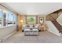 Bright living room featuring large windows, neutral decor, plush carpet, and a cozy seating area at 11402 W 17Th Pl, Lakewood, CO 80215
