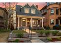 Charming brick home with a covered front porch, columns, and landscaped front yard at 1730 N Gaylord St, Denver, CO 80206