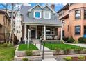 Charming brick home with a covered front porch, columns, and manicured front lawn and garden at 1730 N Gaylord St, Denver, CO 80206