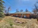 Spacious backyard with a mix of grass and dry patches, bordered by a wooden fence at 4291 W Wagon Trail Dr, Littleton, CO 80123