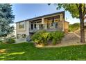 Backyard featuring a covered patio, stone accents, a grassy yard, and mature trees at 11017 Meade Ct, Westminster, CO 80031