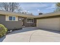 Charming single-story home features a well-manicured lawn, a driveway, and a two-car garage at 5876 W Canyon Ave, Littleton, CO 80128