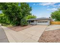 Charming single-story home with a well-maintained lawn, large driveway, and attached two-car garage at 8231 E Lehigh Dr, Denver, CO 80237