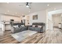 Open-concept living room with hardwood floors and neutral colors leads into kitchen with white cabinetry at 9012 Borrowdale Ln, Parker, CO 80134
