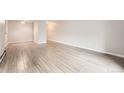 Open living room featuring neutral walls and light-toned wood-look tile flooring, offering versatility in interior design at 2231 S Vaughn Way # 205B, Aurora, CO 80014