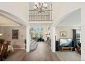 Bright, open foyer with hardwood floors, a grand staircase, chandelier and views into the living spaces at 10 Sand Cherry, Littleton, CO 80127