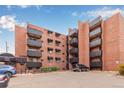 Brick apartment building with black metal balconies and well maintained landscaping offers urban living at 1833 N Williams St # 101, Denver, CO 80218