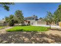 Expansive backyard with lush lawn, mature trees, and wooden pergola on the patio at 4351 E 109Th Ave, Thornton, CO 80233