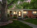 Charming front porch with brick accents and a well-maintained lawn and mature trees at 9656 Rensselaer Dr, Arvada, CO 80004
