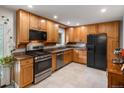 Well-lit kitchen featuring wooden cabinets, granite countertops, and stainless steel appliances at 9656 Rensselaer Dr, Arvada, CO 80004