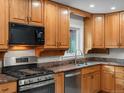 Traditional-style kitchen with granite countertops, stainless steel appliances, and wooden cabinets at 9656 Rensselaer Dr, Arvada, CO 80004