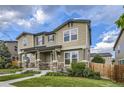 Townhome exterior featuring stone accents, a covered porch, and a green lawn at 2356 W 165Th Pl, Broomfield, CO 80023