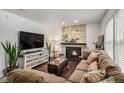 Cozy living room featuring a stone fireplace, plush seating, and hardwood floors at 8691 Bluebunch Ct, Parker, CO 80134