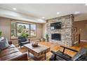 Inviting living room with hardwood floors, stone fireplace, and a bright bay window at 12752 W Asbury Pl, Lakewood, CO 80228