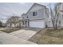 Two-story home with gray siding and a two-car garage and long driveway at 5547 Himalaya Rd, Denver, CO 80249