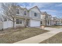 Two-story home featuring gray siding, a two-car garage, and a 
