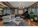 Beautifully decorated living room features a grand piano, stylish furniture, and large windows, offering a refined living space at 25312 E Glasgow Pl, Aurora, CO 80016