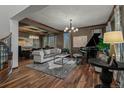 Elegant living room featuring a grand piano, stylish seating, and hardwood floors at 25312 E Glasgow Pl, Aurora, CO 80016