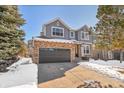 Two-story house with gray siding, stone accents, and a dark brown garage door at 25325 E Park Crescent Dr, Aurora, CO 80016